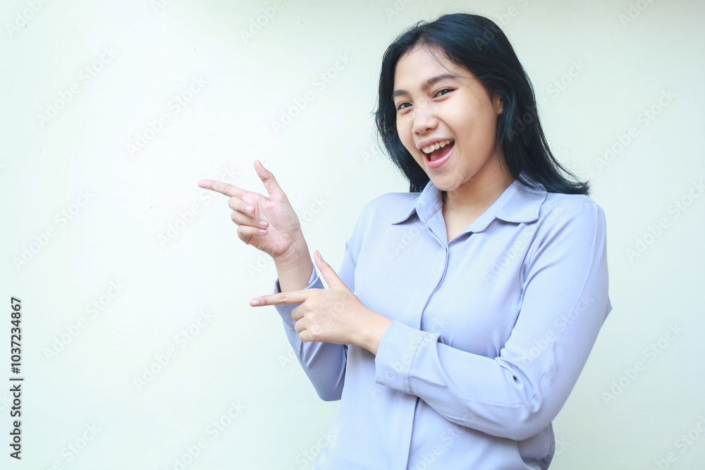 presenting asian young woman pointing finger to side looking to camera smiling with excitement, wearing formal shirt isolated on white background presenting asian young woman pointing finger to side looking to camera smiling with excitement, wearing formal shirt isolated on white background