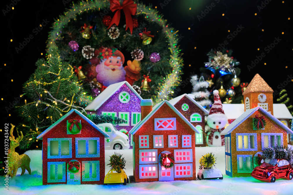 A large Christmas town with a chapel and large decorated houses with green and pink lights in the windows and cars, a snowman and a deer near them A large Christmas town with a chapel and large decorated houses with green and pink lights in the windows and cars, a snowman and a deer near them