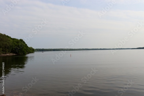 The calm lake on a foggy sunny morning.