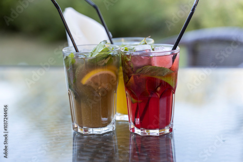 Three drinks with straws in them are on a table photo