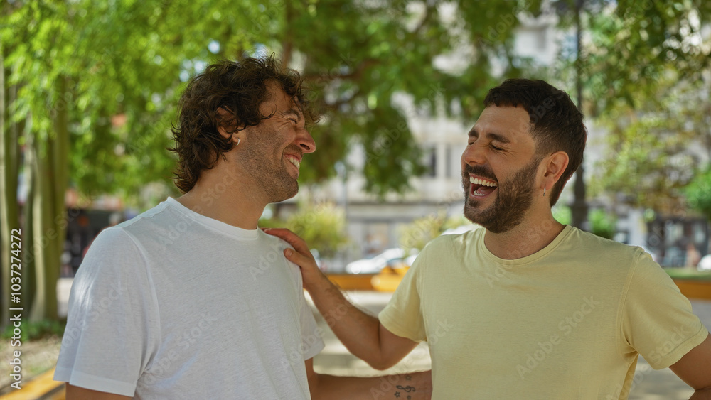 Men laughing together in an outdoor urban park, sharing a joyful and friendly moment under the trees