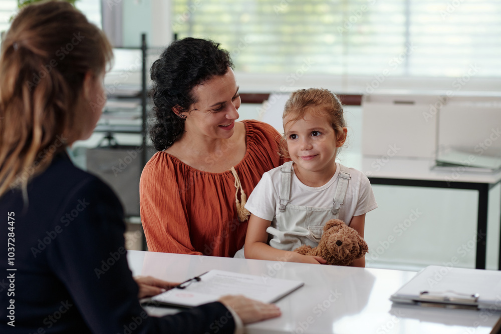 Woman with child talking to social worker during meeting in office Woman with child talking to social worker during meeting in office