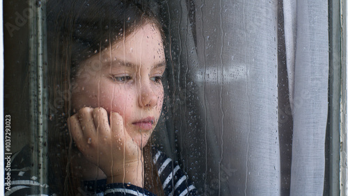 Caucasian little girl looking out window rainy weather dropping sadness anxiety stress crisis divorce unhappy child offspring kid psychological trauma descendant despondency schoolgirl pupil lonely