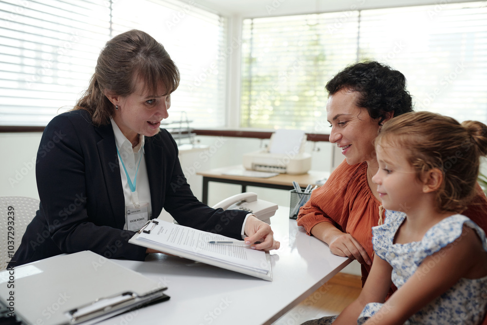 Social worker discussing agreement with family during their visit to social service Social worker discussing agreement with family during their visit to social service
