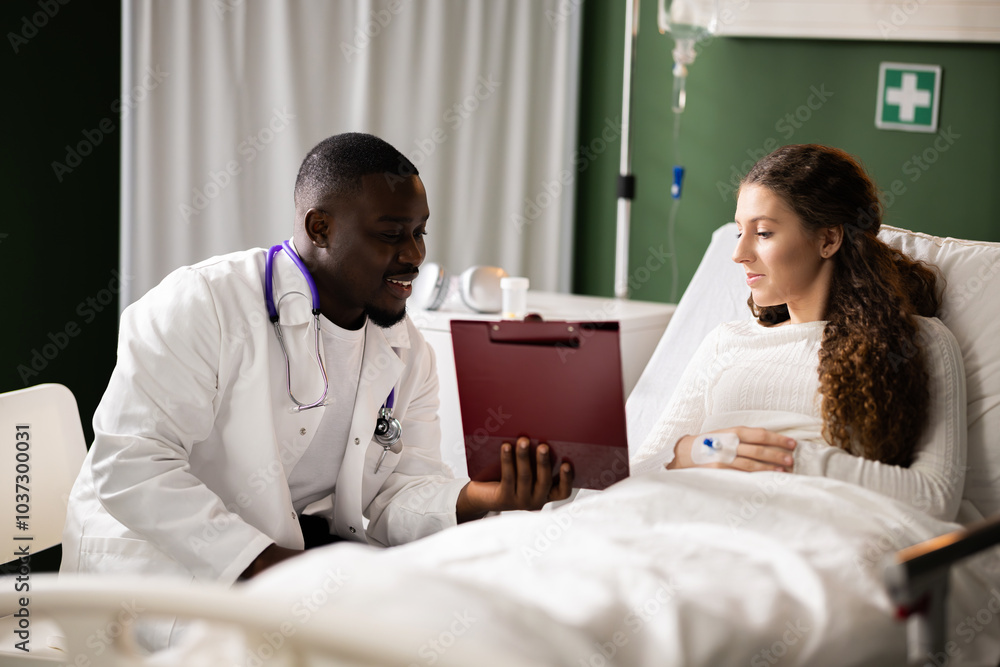 Young African doctor sits by the red-haired girl, presenting information from a folder during a consultation. Young African doctor sits by the red-haired girl, presenting information from a folder during a consultation.