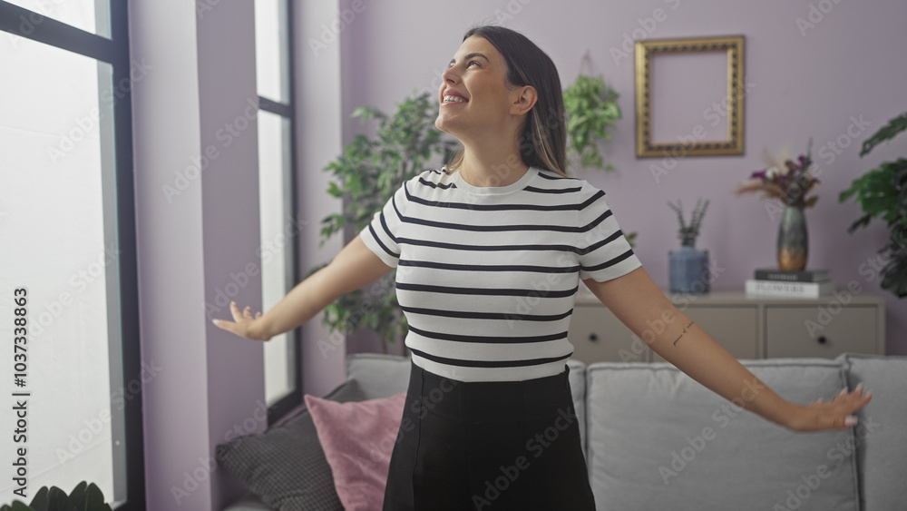 Happy woman enjoying comfort in a modern styled living room with purple walls and decorative plants. Happy woman enjoying comfort in a modern styled living room with purple walls and decorative plants.