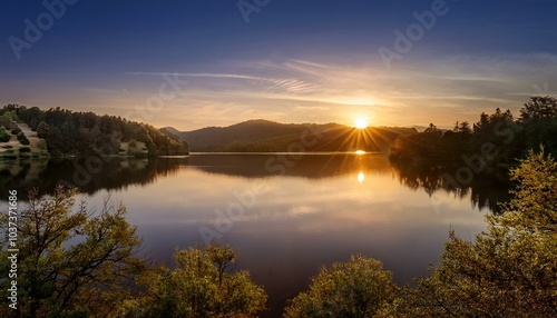 the sun sets over a tranquil lake casting a warm glow and stunning reflection of hills and trees perfect for relaxation seekers in nature photo