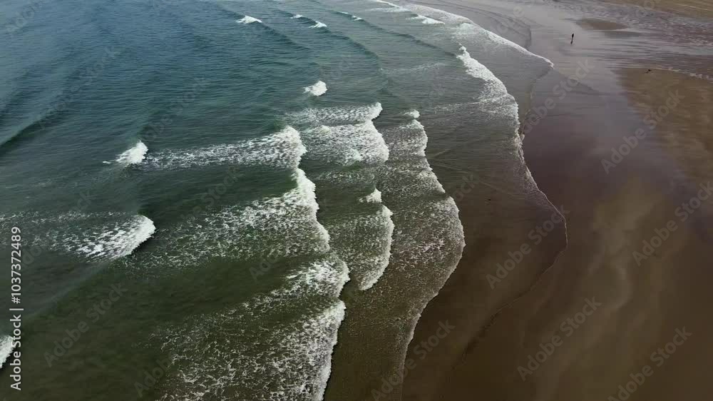 The water is a clear, sparkling blue. The waves are breaking gently on the shore. The water is a clear, sparkling blue. The waves are breaking gently on the shore.