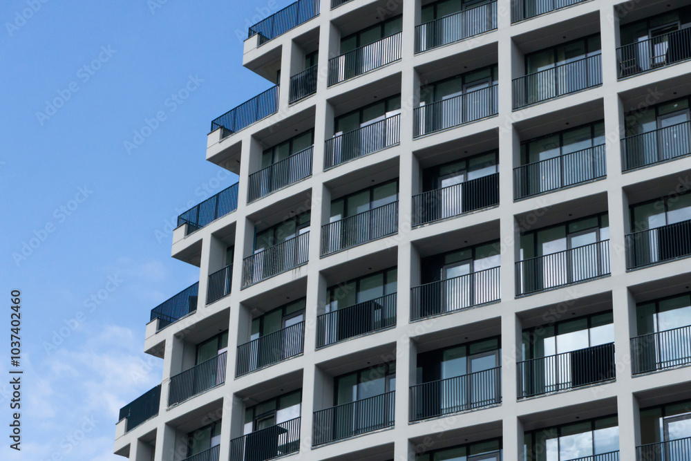 Newly built modern apartment building with glass apartments and balconies. Large windows block of flats. Stylish urban landscape. Futuristic architecture. Newly built modern apartment building with glass apartments and balconies. Large windows block of flats. Stylish urban landscape. Futuristic architecture.