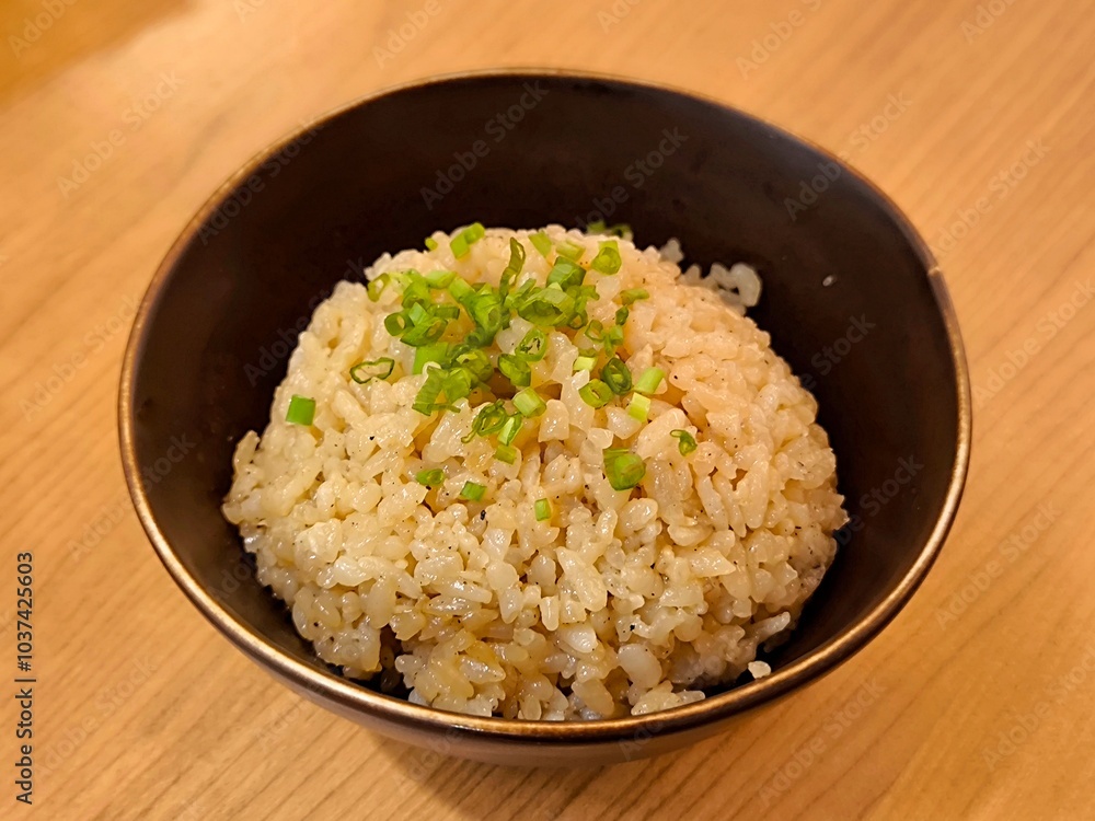 Japanese garlic fried rice in ceramic bowl on wood table. Food menu concept Japanese garlic fried rice in ceramic bowl on wood table. Food menu concept