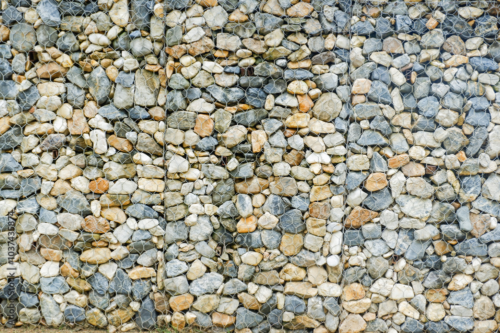 Modern Privacy Fence of Natural Rock Gabions, Walls made of stone and iron Made by welding steel into a sieve and then put the stone in the middle,style of hotel or office Building,Selective focus. Modern Privacy Fence of Natural Rock Gabions, Walls made of stone and iron Made by welding steel into a sieve and then put the stone in the middle,style of hotel or office Building,Selective focus.