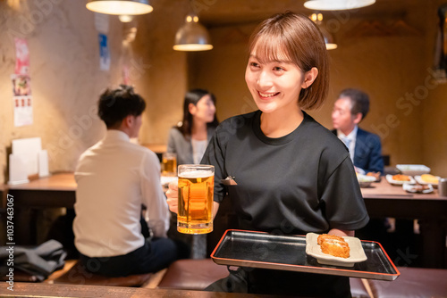 ビールを提供する居酒屋の女性スタッフ