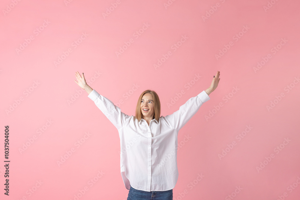 Lifestyle concept. Joyful woman with arms raised in a white shirt and blue jeans against a pink backdrop Lifestyle concept. Joyful woman with arms raised in a white shirt and blue jeans against a pink backdrop