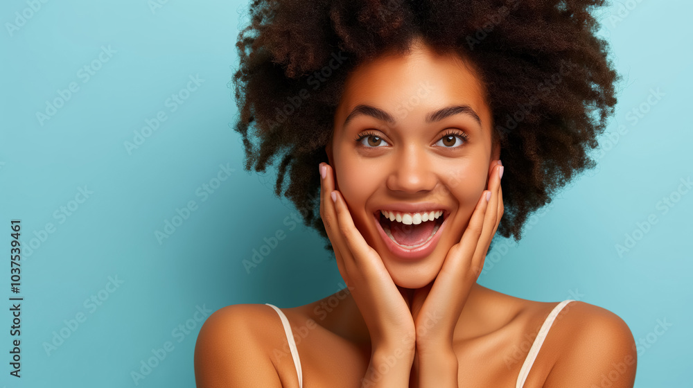 Joyful expression of a young woman with curly hair against blue background Joyful expression of a young woman with curly hair against blue background