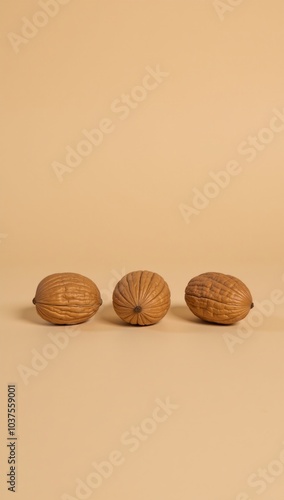 Three walnut shells against a beige backdrop photo