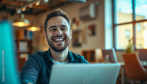 A happy man with a laptop in a contemporary office, showcasing positivity and productivity. The ambient lighting and open space emphasize a relaxed and creative work environment.