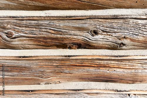 Fotografía Log cabin siding, old wood building, chinking between logs, aged wooden texture