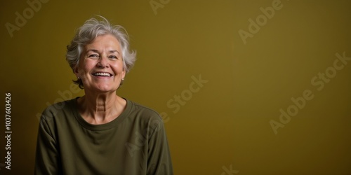 Smiling Elderly Woman with Short Grey Hair Against Olive Green Background

