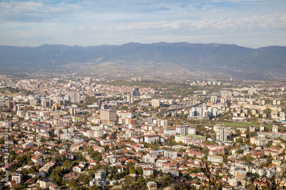 Fototapeta premium Skopje, a thriving urban panorama The city of Skopje, seen from above Aerial view of the Macedonian capital Skopje, a mosaic of colors and shapes where the mountains meet the metropolis.