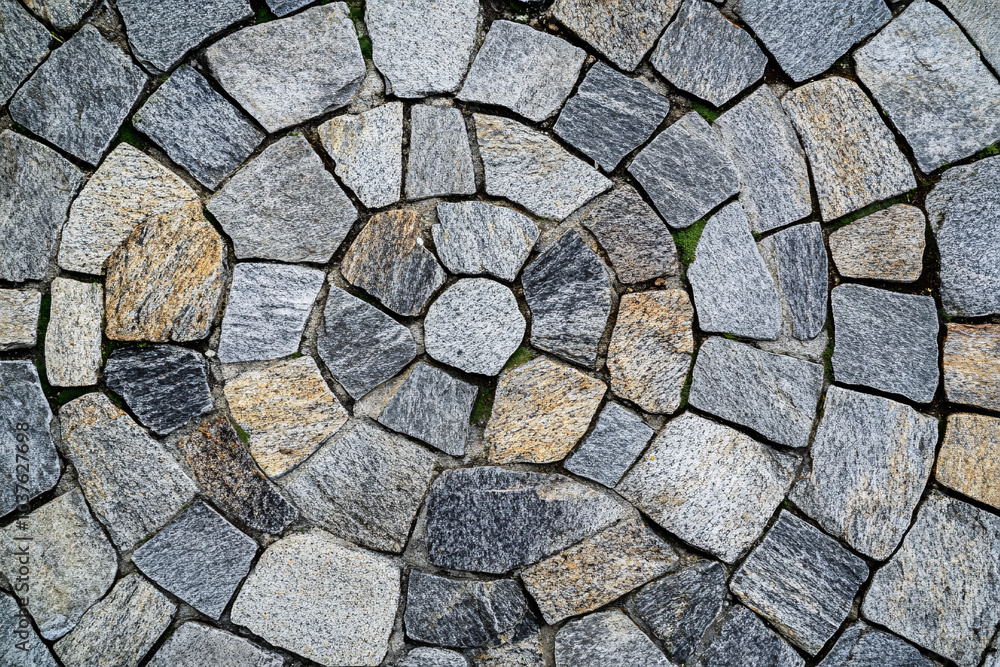 A circular stone pattern with concentric arrangement in shades of gray and beige creating a rustic textured outdoor design
A circular stone pattern with concentric arrangement in shades of gray and beige creating a rustic textured outdoor design