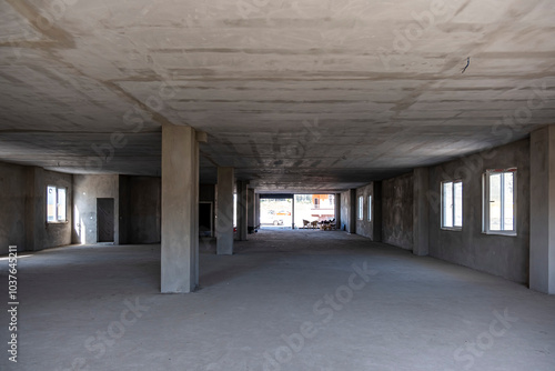 A large empty room with a cement ceiling and a concrete floor