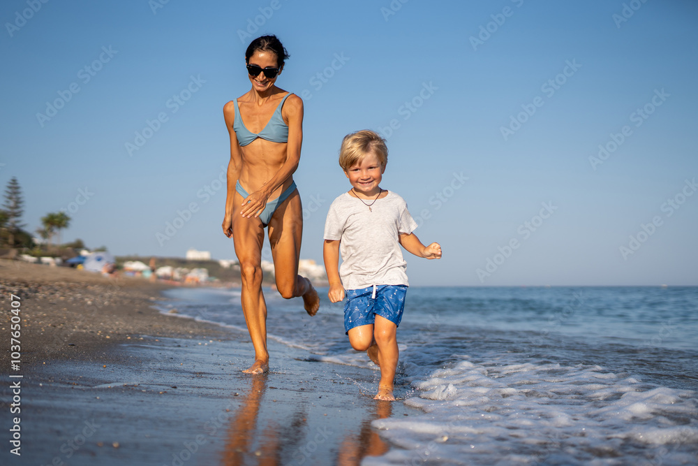Mother and Son Running Together on a Sunny Beach Mother and Son Running Together on a Sunny Beach