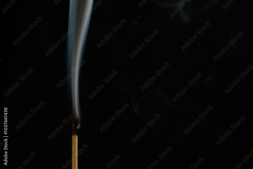Burnt match with trailing smoke after being blown out on a black background Burnt match with trailing smoke after being blown out on a black background