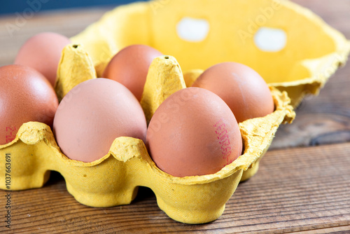 Closeup macro of pasture raised farm fresh dozen brown eggs store bought from farmer in carton box container with speckled eggshells texture photo