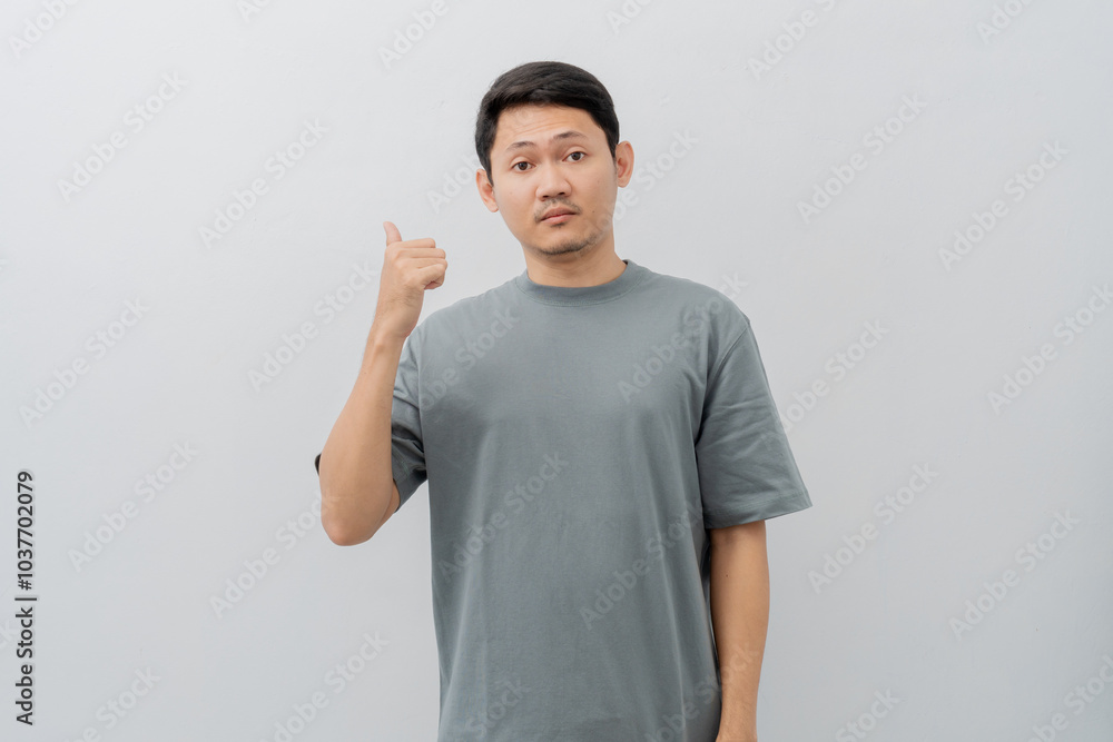 Sad and disappointed expression of adult Asian man pointing fingers with casual t-shirt isolated on white background Sad and disappointed expression of adult Asian man pointing fingers with casual t-shirt isolated on white background