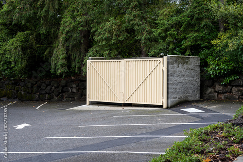 Commercial property parking lot with garbage dumpster enclosure, built from cement blocks and heavy iron doors
