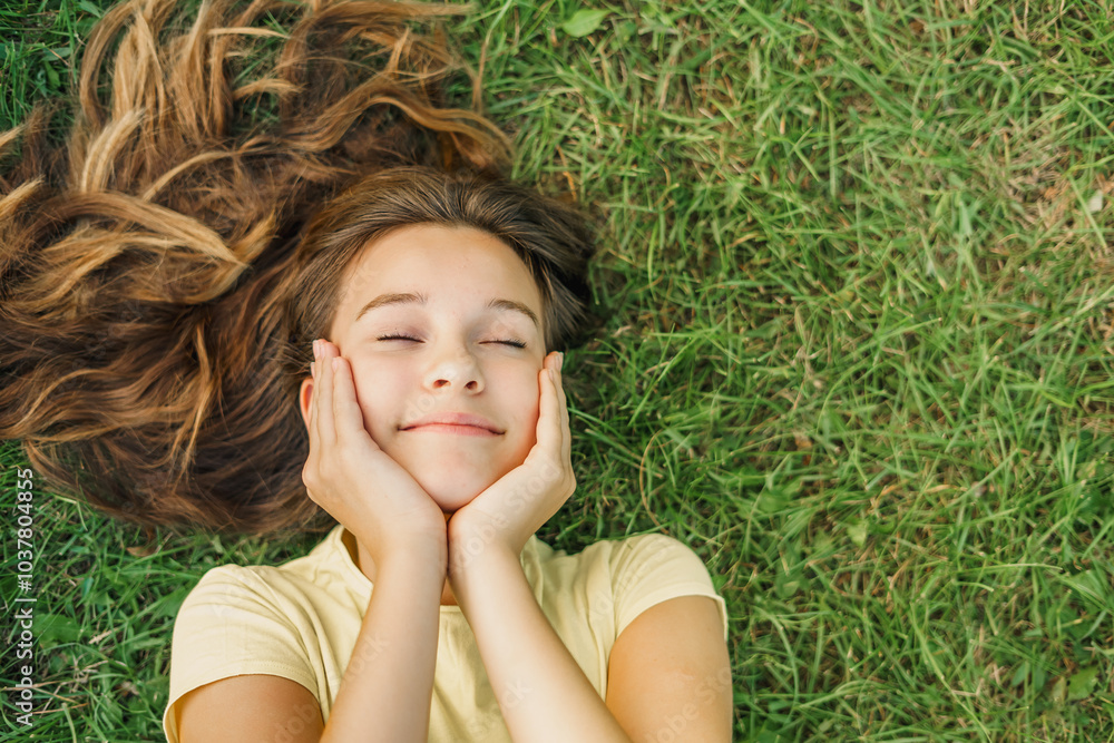 Close up top view high angle photo beautiful young girl child dreamily closed eyes her hands on cheeks natural background green grass Close up top view high angle photo beautiful young girl child dreamily closed eyes her hands on cheeks natural background green grass
