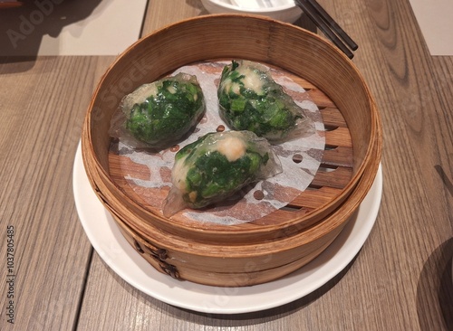 Steamed Green spinach Dumplings in Bamboo Steamer at Chinese Restaurant, Singapore