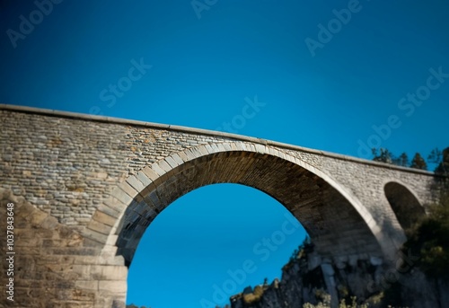 Stone arch bridge against a blue sky.