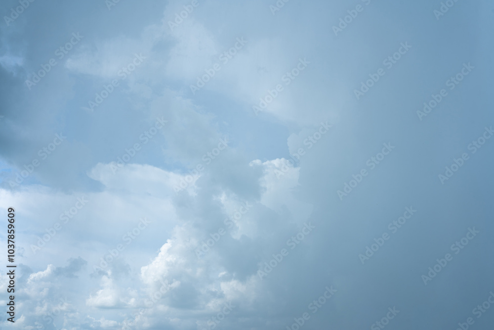 Fluffy white clouds drift across a clear blue sky, casting soft shadows on the Earth Fluffy white clouds drift across a clear blue sky, casting soft shadows on the Earth