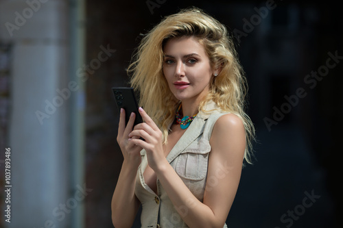 Woman talking on phone. Attractive woman using smart phone outdoors. Outdoor portrait of pretty woman speaking on the phone in urban city. Outdoor talk on phone. Girl making selfie on phones. photo