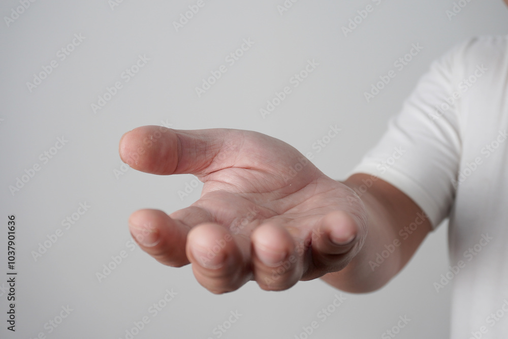 Male person hand reach out asking for help, begging for donation, over grey Male person hand reach out asking for help, begging for donation, over grey