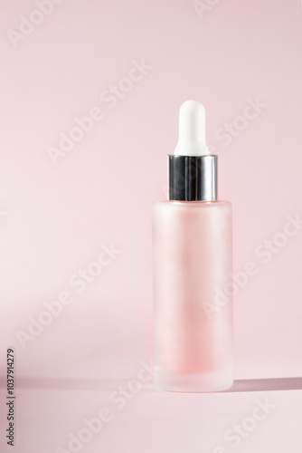 Abstract pink glass dropper bottle with a silver cap against a soft pink background. Skincare or cosmetic product promotions.