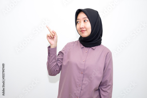 portrait of Indonesian Asian woman wearing shirt and hijab pointing with one and two hands to right, left and front. pointing to empty direction for advertising space.. Isolated on white background