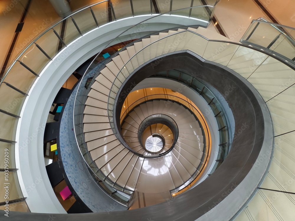Fototapeta premium A beautifully designed spiral staircase in a modern building with glass railing