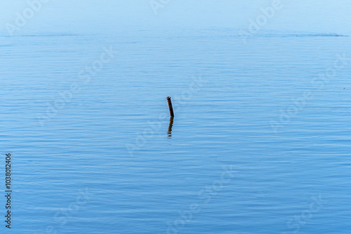 Lonely pipe protruding from the surface of the calm water of the Mediterranean Sea at the mouth of the Ebro River.