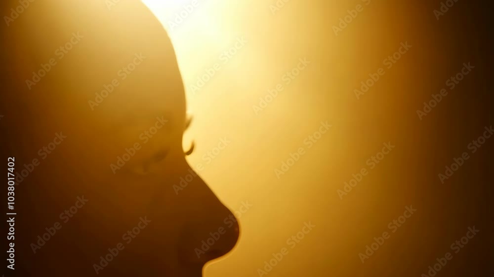 Silhouette of a person in warm light with golden background Silhouette of a person in warm light with golden background