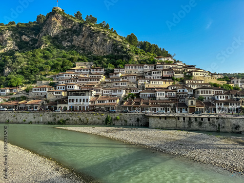 Panoramic view from footbridge Gorica over river Osum leading to Berat castle on hilltop in Albania. UNESCO World Heritage Site with well-preserved Ottoman-era architecture. City of thousand windows