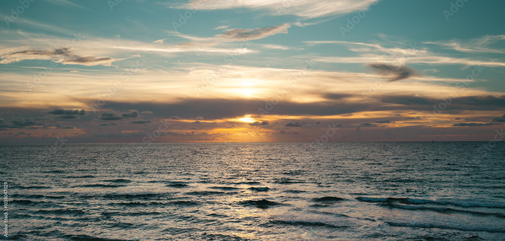 Fototapeta premium Sea beach with sky sunset or sunrise. Clouds over the sunset sea. Sunset at tropical beach. Nature sunset landscape of sunshine sea.