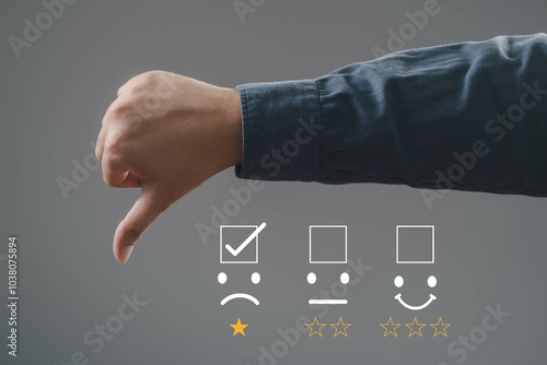 A hand showing a thumbs down gesture with feedback icons representing dissatisfaction. Ideal for critique or review concepts. photo