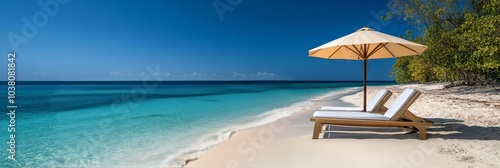 Relaxing on a sunny beach with lounge chairs and an umbrella by the clear blu...