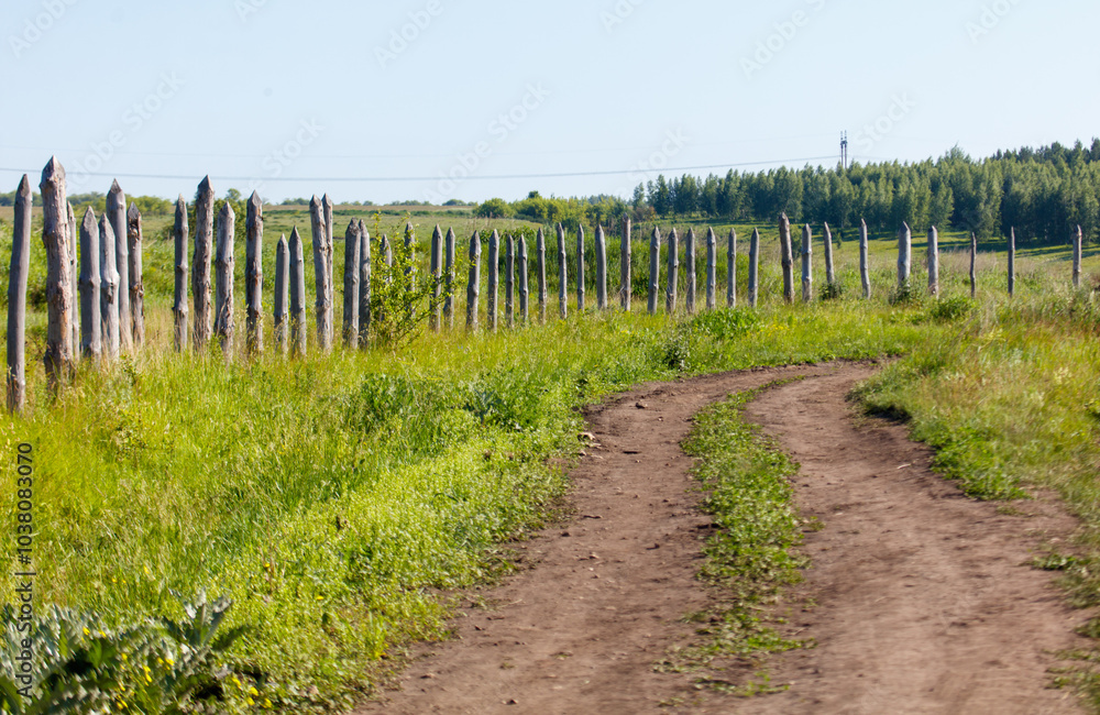 Obraz premium A dirt road with a fence in the background