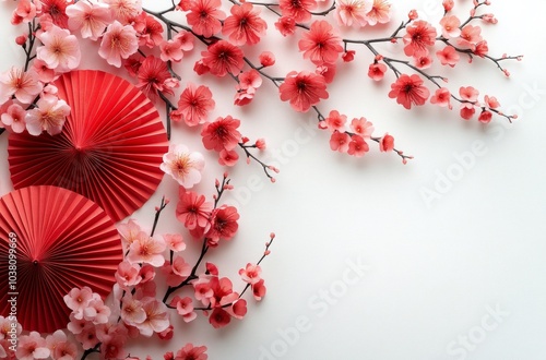 Delicate red fans and cherry blossoms arranged artistically on a light backgr...
