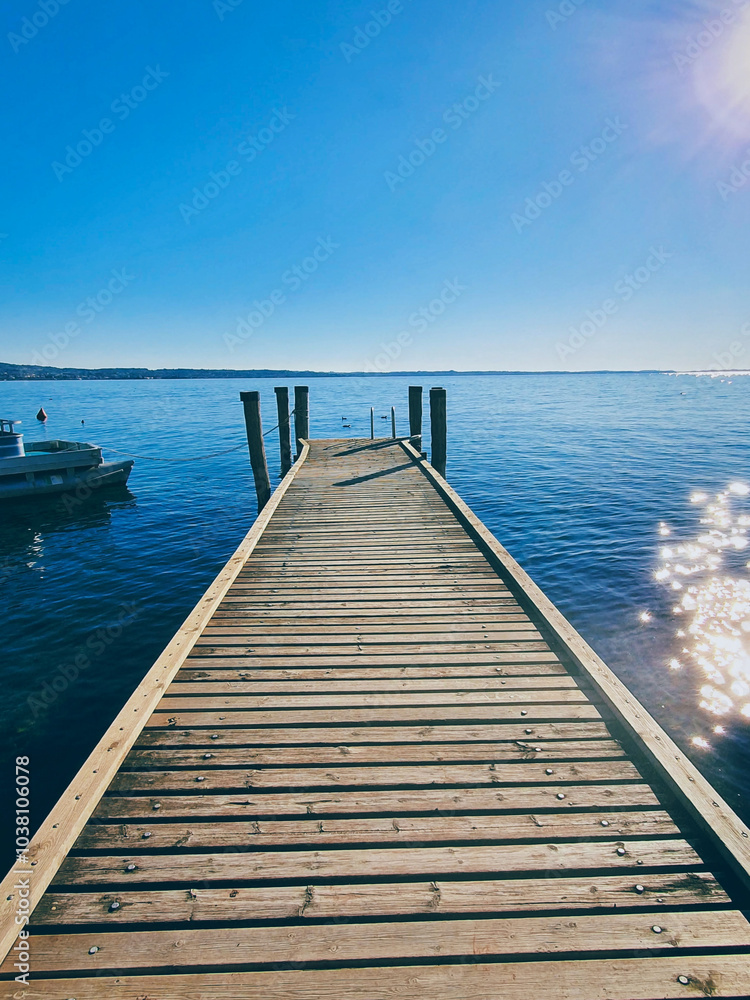 Fototapeta premium A pier over Lake Garda in Italy, the horizon at the distance