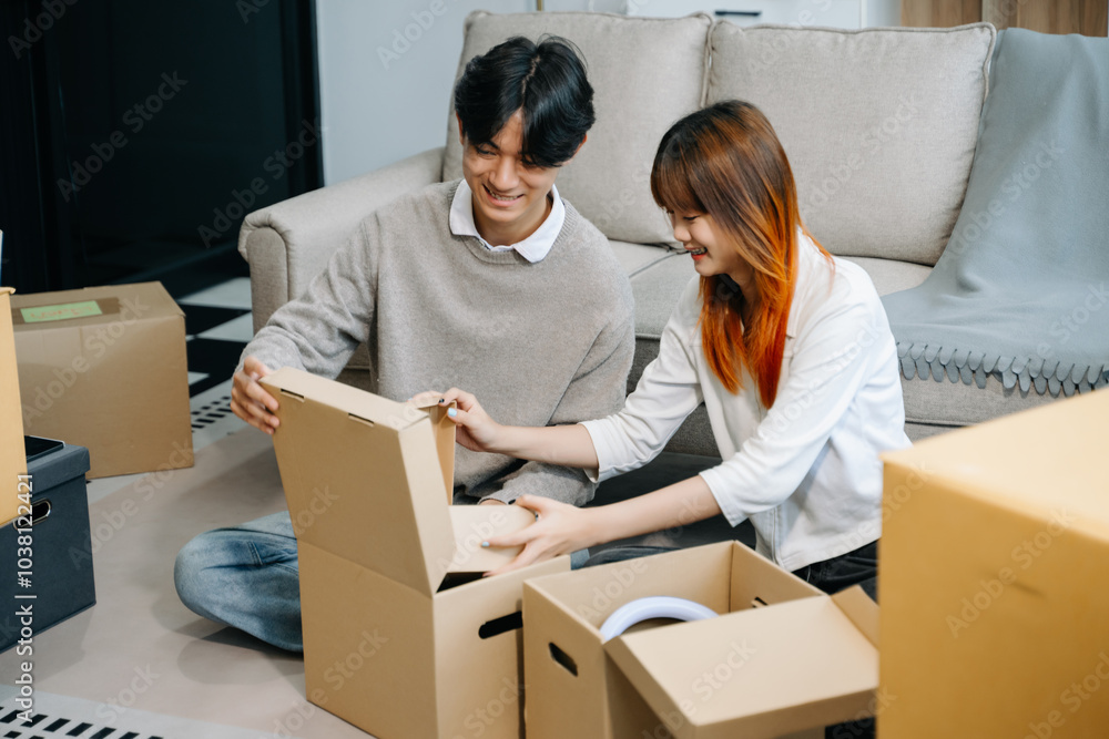 Young couple with big boxes moving into a new house, new apartment for couple, young asian man and woman helping to lift boxes on sofa for Young couple with big boxes moving into a new house, new apartment for couple, young asian man and woman helping to lift boxes on sofa for