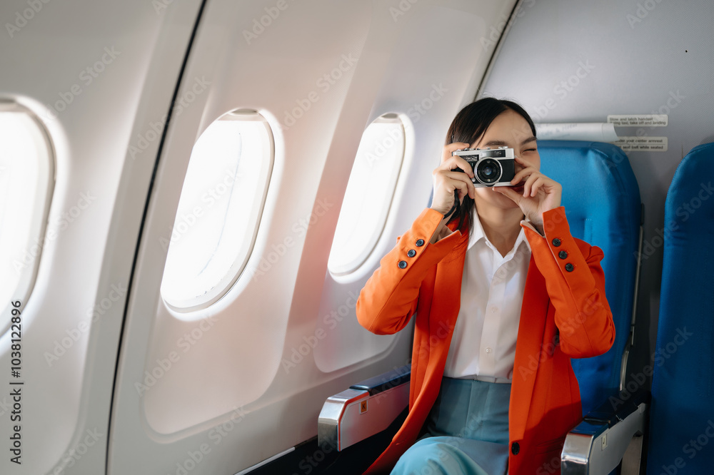 Naklejka premium Asian woman sitting in a seat in airplane and looking out the window going on a trip vacation travel concept.Capture the allure of wanderlust .